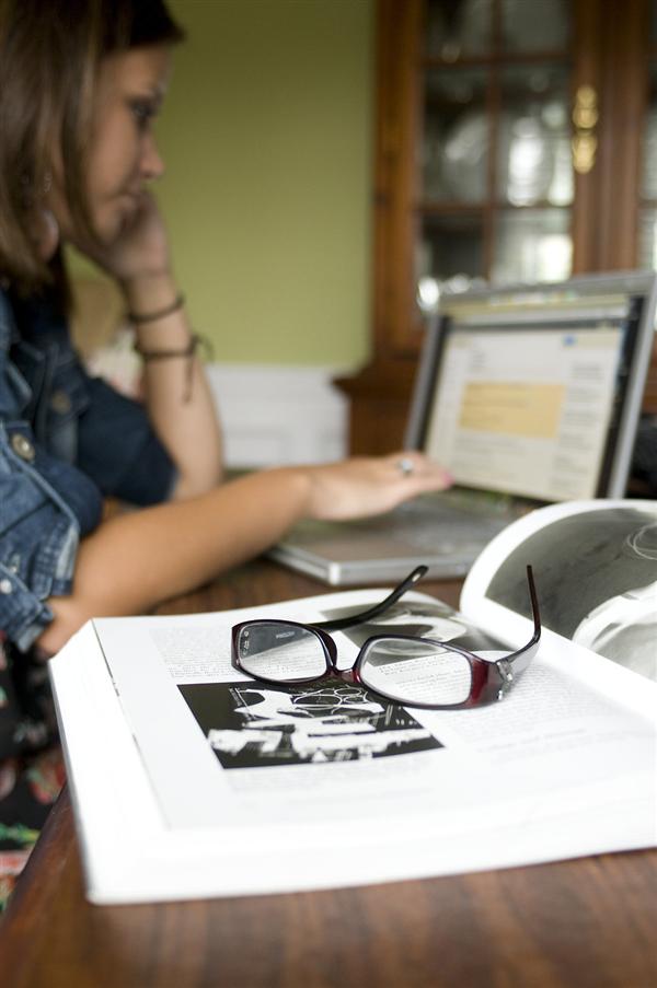 Girl using laptop to supplement book reading Girl using laptop to supplement book reading